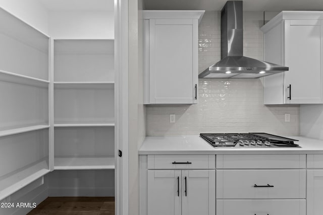 kitchen with wall chimney exhaust hood, white cabinetry, and stainless steel gas stovetop