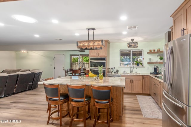 3136 W Sunnyside Ave, Phoenix, AZ 85029 - kitchen featuring decorative light fixtures, sink, a center island, light hardwood / wood-style floors, and stainless steel appliances