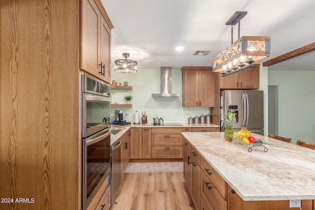 3136 W Sunnyside Ave, Phoenix, AZ 85029 - kitchen with wall chimney range hood, appliances with stainless steel finishes, a center island, light hardwood / wood-style floors, and decorative light fixtures