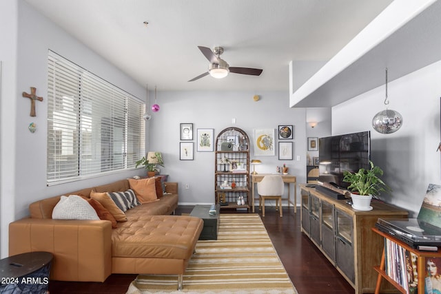 living room featuring ceiling fan with notable chandelier and dark hardwood / wood-style flooring