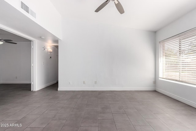 empty room with ceiling fan, visible vents, and baseboards