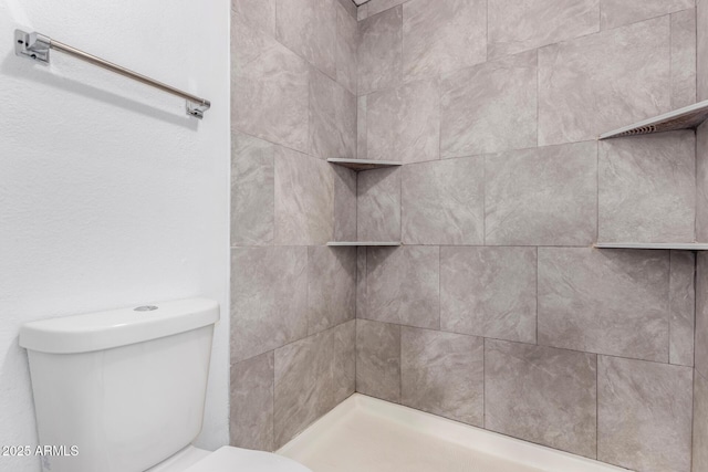 full bath featuring toilet and tiled shower