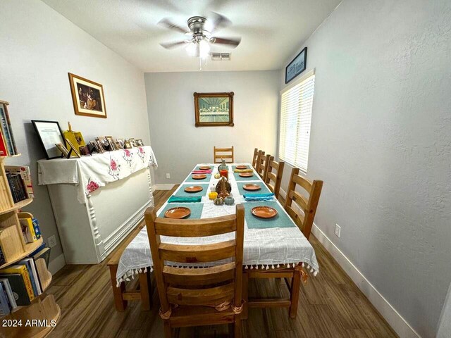 dining space with dark wood-type flooring and ceiling fan