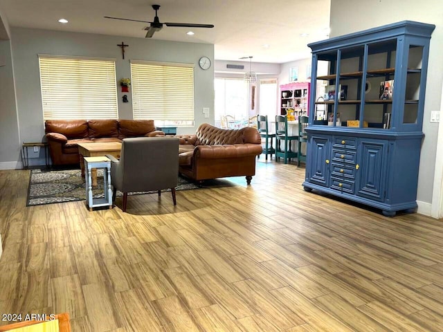 living room with ceiling fan and light hardwood / wood-style flooring