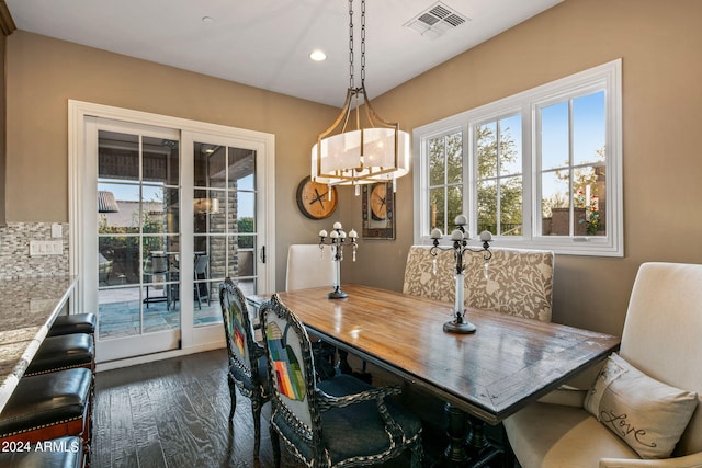 dining area with a notable chandelier and dark hardwood / wood-style floors