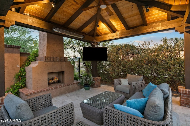 view of patio with a gazebo, ceiling fan, and an outdoor living space with a fireplace