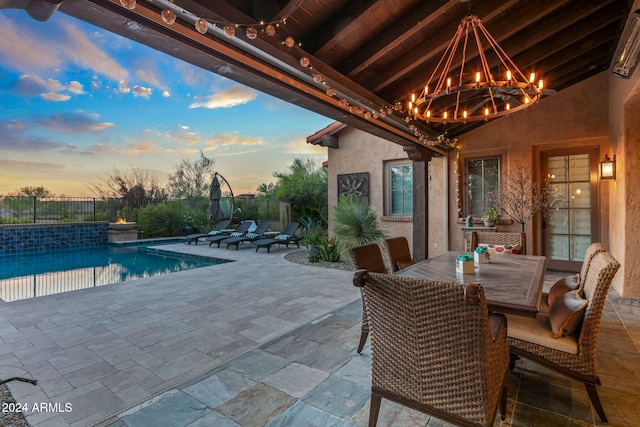 patio terrace at dusk featuring a fenced in pool