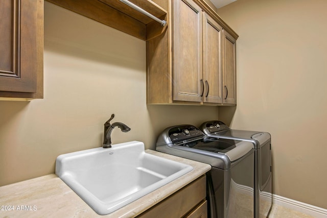 washroom with sink, independent washer and dryer, and cabinets