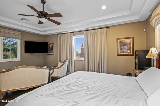 bedroom featuring hardwood / wood-style floors, a tray ceiling, and ceiling fan