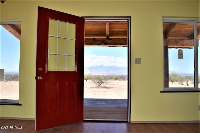 entryway featuring dark hardwood / wood-style floors, beam ceiling, a mountain view, and wood ceiling