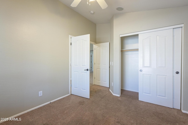 unfurnished bedroom with light carpet, a closet, vaulted ceiling, and ceiling fan