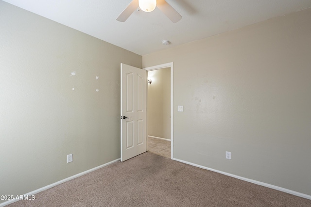 spare room featuring light carpet and ceiling fan