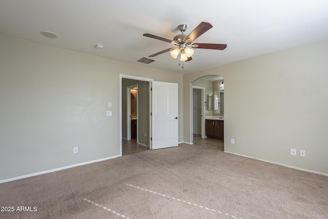 unfurnished bedroom with carpet, ceiling fan, and ensuite bath