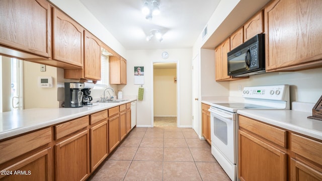 kitchen featuring sink, light tile patterned floors, and white appliances