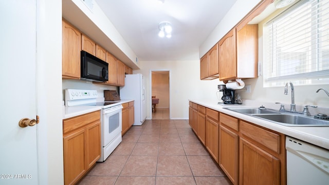 kitchen featuring sink, white appliances, and light tile patterned flooring