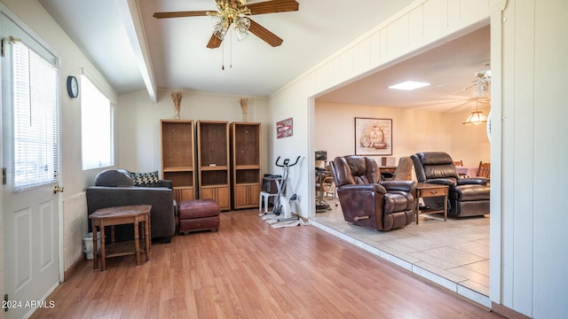 living room featuring light hardwood / wood-style flooring, lofted ceiling with beams, and ceiling fan