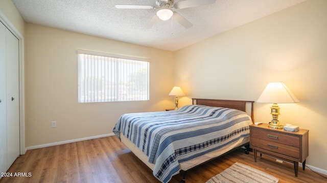 bedroom with ceiling fan, hardwood / wood-style floors, a closet, and a textured ceiling