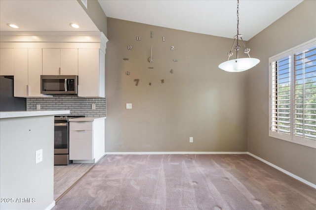 9600 N 96th St Unit 263, Scottsdale, AZ 85258 - kitchen featuring stainless steel appliances, light countertops, light colored carpet, decorative light fixtures, and decorative backsplash
