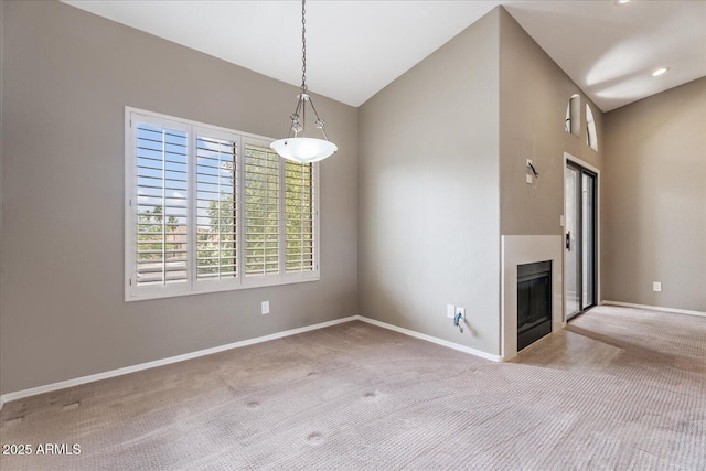 9600 N 96th St Unit 263, Scottsdale, AZ 85258 - unfurnished dining area with carpet flooring, a fireplace with flush hearth, baseboards, and vaulted ceiling