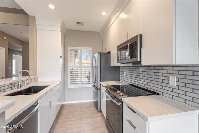 9600 N 96th St Unit 263, Scottsdale, AZ 85258 - kitchen with appliances with stainless steel finishes, a sink, tasteful backsplash, white cabinetry, and recessed lighting