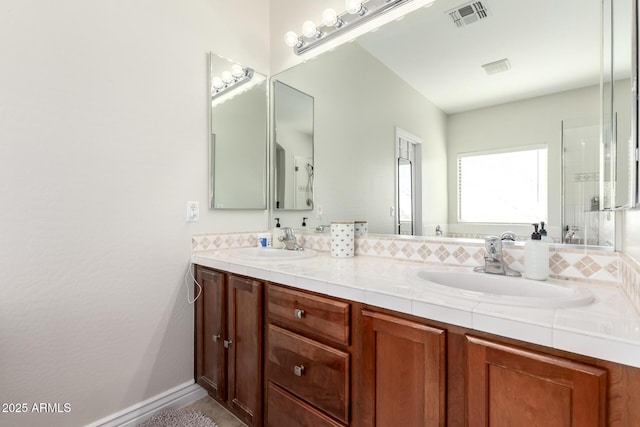 full bathroom featuring double vanity, a sink, visible vents, and baseboards