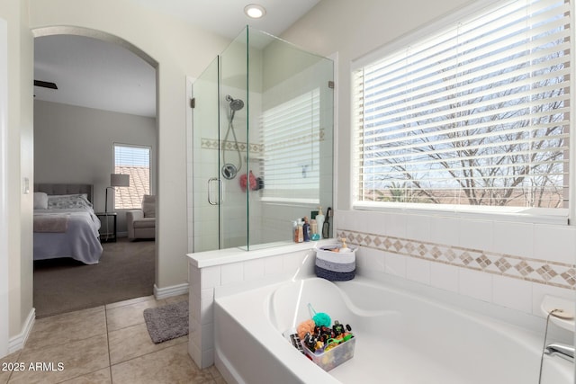 ensuite bathroom with baseboards, ensuite bath, tile patterned floors, a shower stall, and a bath