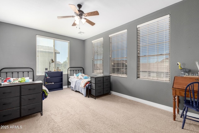 carpeted bedroom with a ceiling fan, visible vents, and baseboards