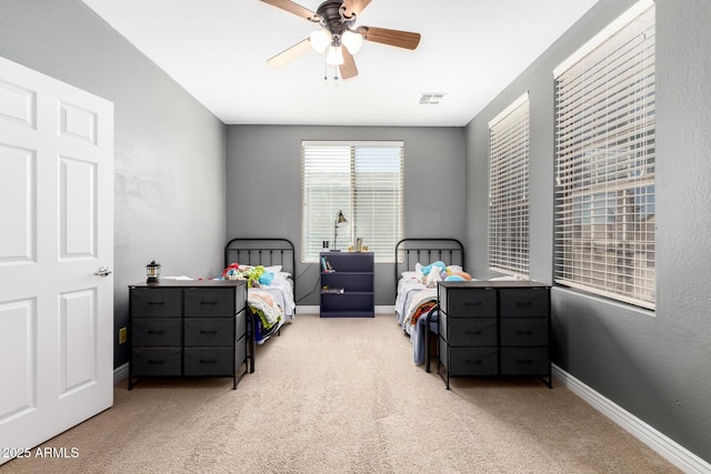 bedroom with light carpet, visible vents, baseboards, and ceiling fan