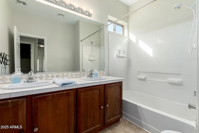 bathroom with double vanity, a sink, and visible vents