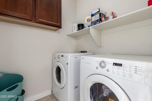 washroom featuring washer and dryer, cabinet space, baseboards, and light tile patterned floors