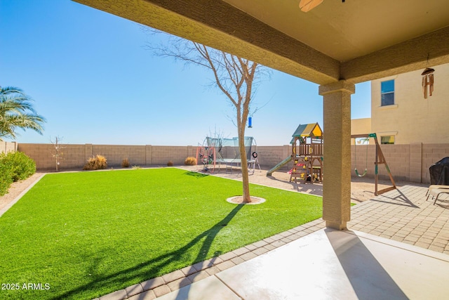 view of yard featuring a fenced backyard, a playground, and a patio