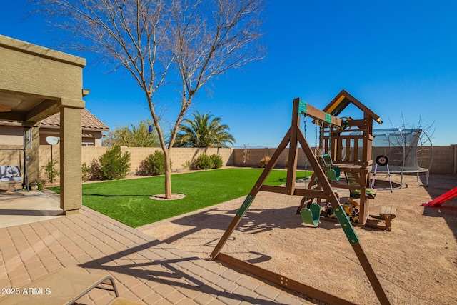 view of playground featuring a fenced backyard, a trampoline, a lawn, and a patio