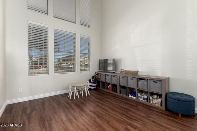 recreation room featuring dark wood-type flooring and baseboards