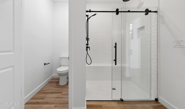 bathroom featuring toilet, hardwood / wood-style flooring, and walk in shower