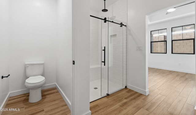 bathroom featuring hardwood / wood-style flooring, toilet, and walk in shower