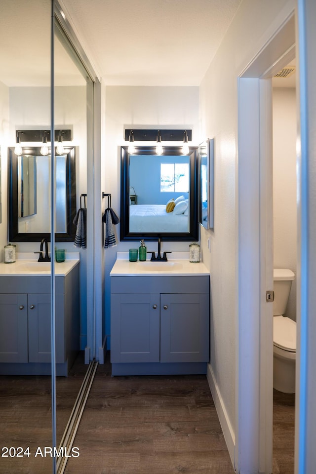 bathroom featuring vanity, wood-type flooring, and toilet