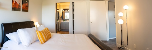 bedroom featuring dark wood-type flooring and connected bathroom