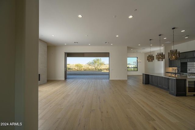 13272 E Ln Junta Rd, Scottsdale, AZ 85255 - unfurnished living room with recessed lighting, light wood-style floors, baseboards, a fireplace, and a chandelier