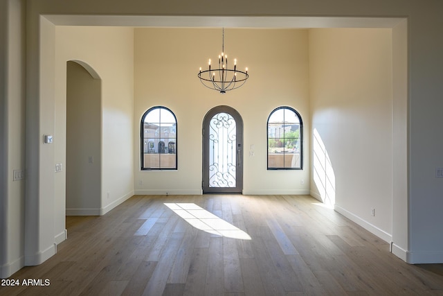 13272 E Ln Junta Rd, Scottsdale, AZ 85255 - foyer with arched walkways, wood finished floors, a chandelier, baseboards, and a towering ceiling