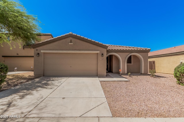 3719 W Carson Rd, Phoenix, AZ 85041 - mediterranean / spanish-style home with concrete driveway, an attached garage, stucco siding, and a tiled roof