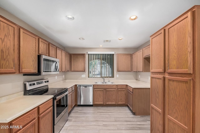 3719 W Carson Rd, Phoenix, AZ 85041 - kitchen featuring stainless steel appliances, light wood-style flooring, brown cabinetry, recessed lighting, and light countertops