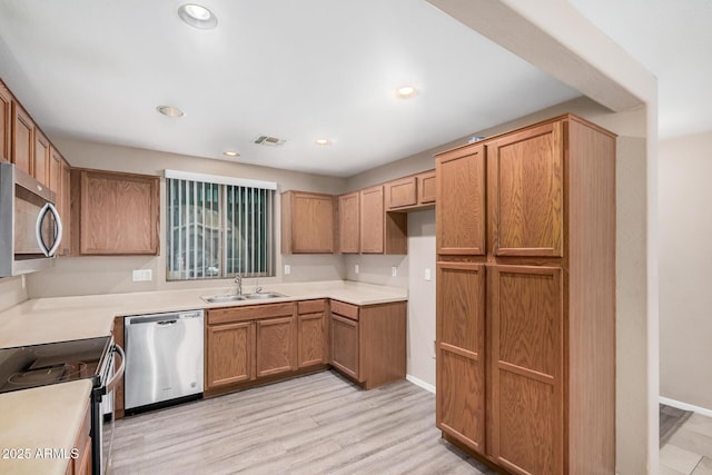 3719 W Carson Rd, Phoenix, AZ 85041 - kitchen featuring appliances with stainless steel finishes, light wood-style flooring, light countertops, recessed lighting, and brown cabinets