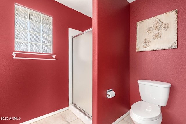 bathroom featuring toilet, a shower with shower door, and tile patterned flooring