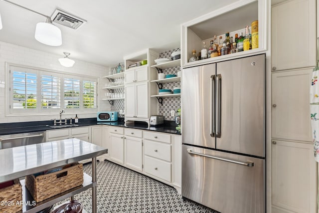3201 E Colter St, Phoenix, AZ 85018 - kitchen with stainless steel appliances, open shelves, white cabinets, dark countertops, and decorative backsplash