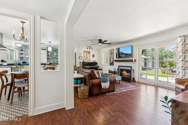 3201 E Colter St, Phoenix, AZ 85018 - living room with a brick fireplace, ceiling fan, wood finished floors, and a chandelier
