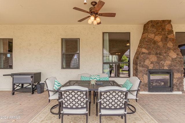 view of patio / terrace featuring outdoor dining space and an outdoor stone fireplace