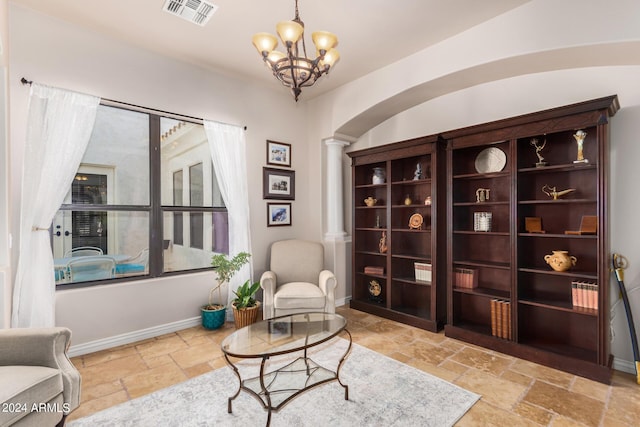 sitting room with an inviting chandelier, stone tile floors, baseboards, decorative columns, and visible vents