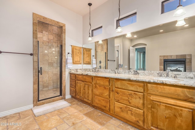 full bath featuring a sink, baseboards, a high ceiling, and a shower stall