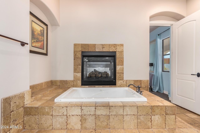 bathroom featuring a bath and a fireplace