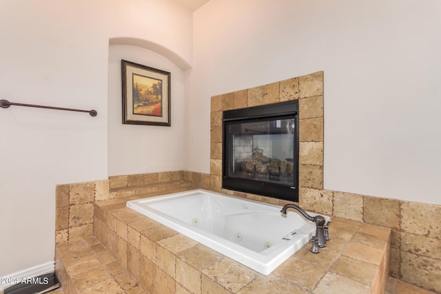 full bathroom featuring a tub with jets and a tile fireplace